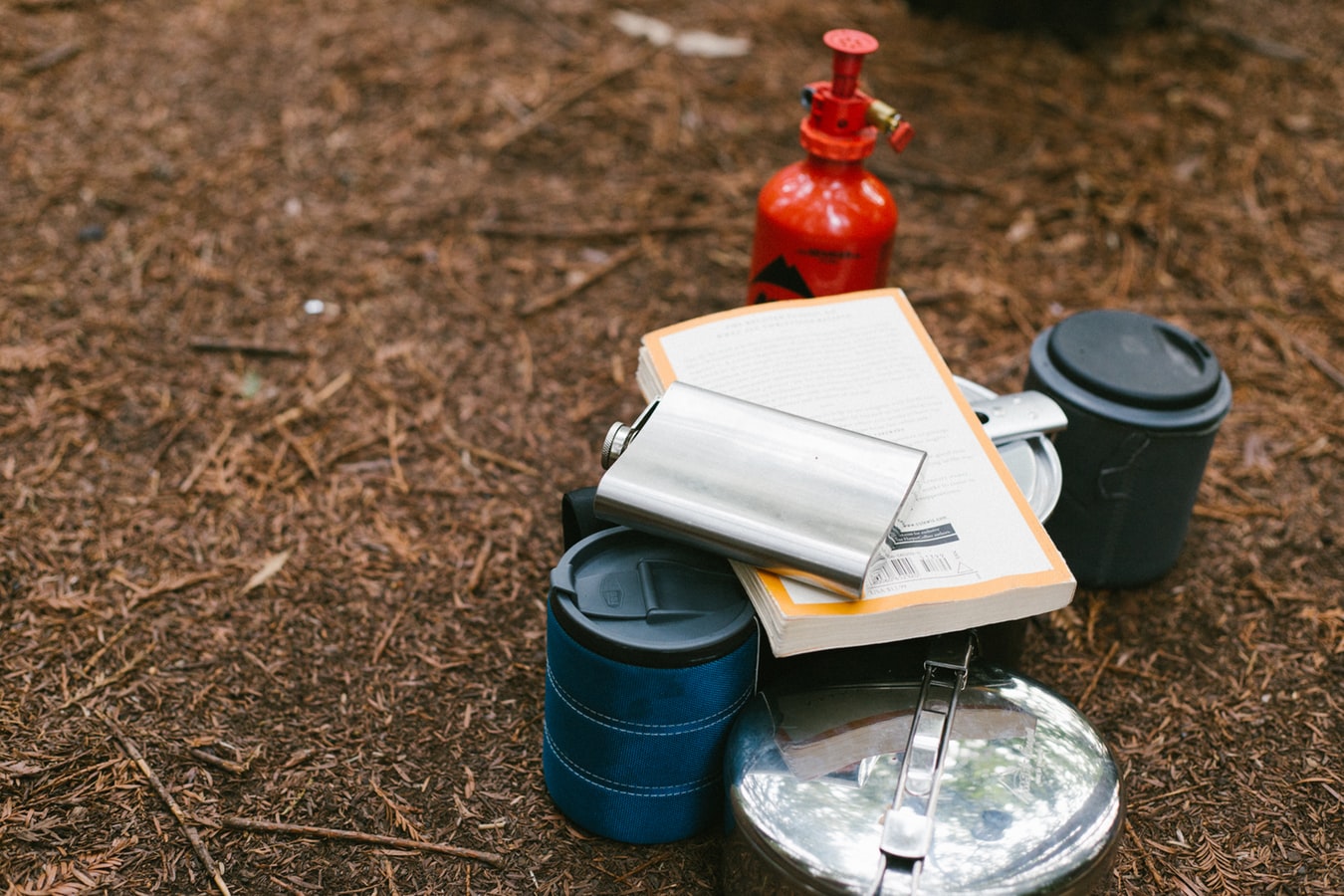 Packed belongings for a camping trip. Kettle, thermos and fire safety equipment.