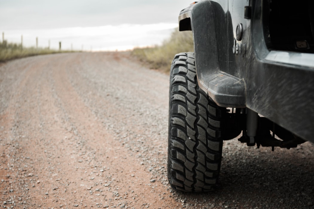 Black four wheel drive on a deserted dirt road