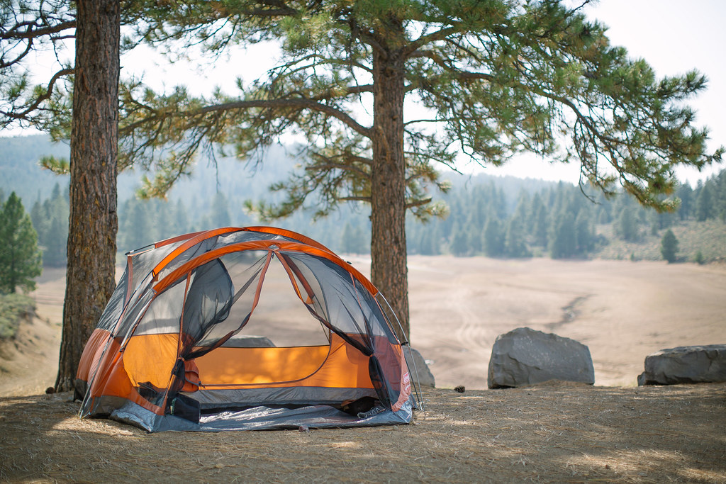 small orange pop tent sitting on a dirt hill