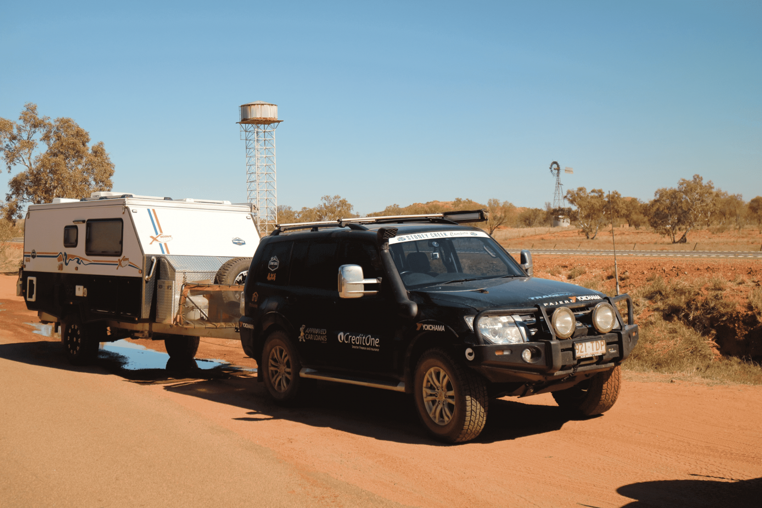 Black 4WD towing a caravan