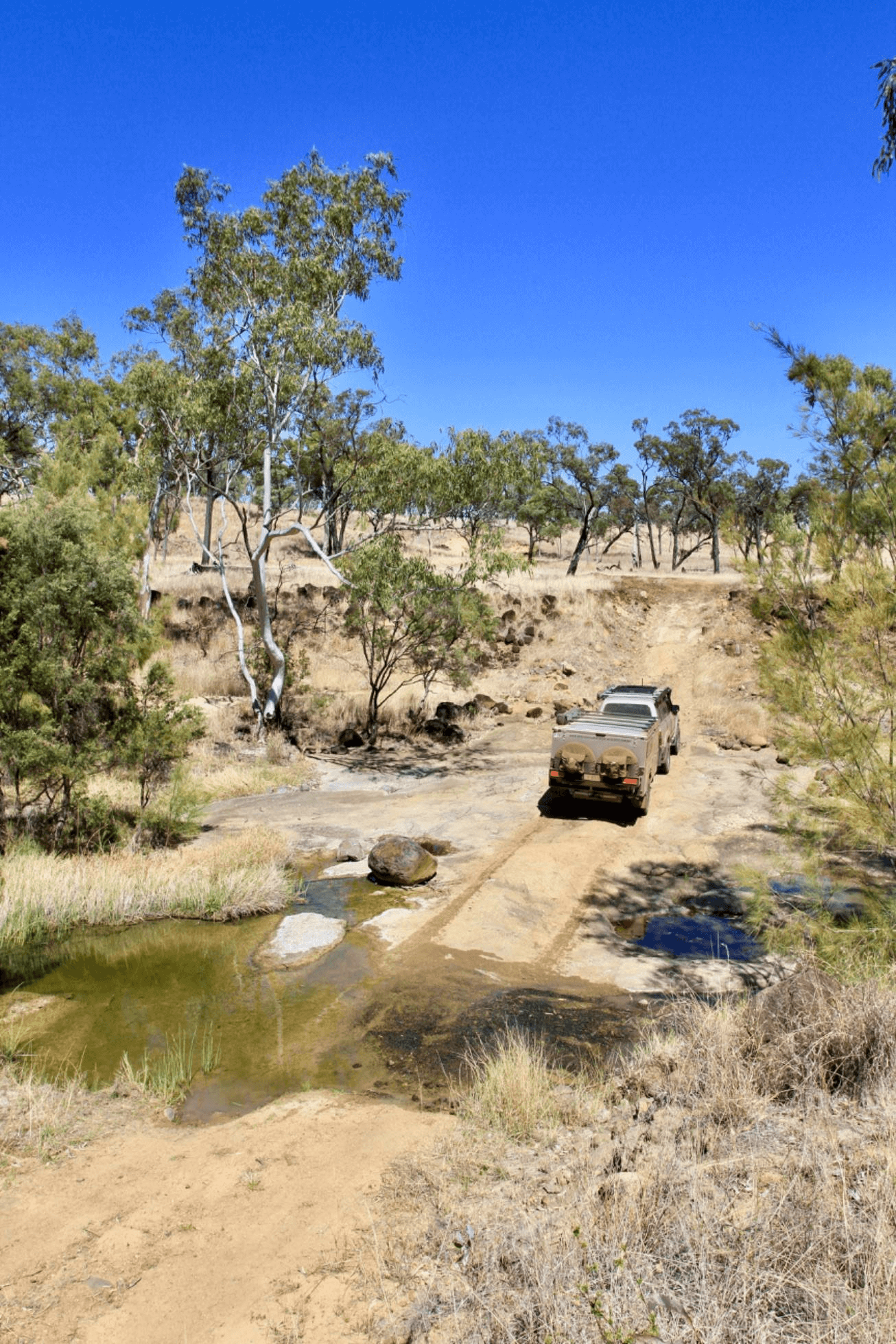 4WD heading up hill in Australian bush.