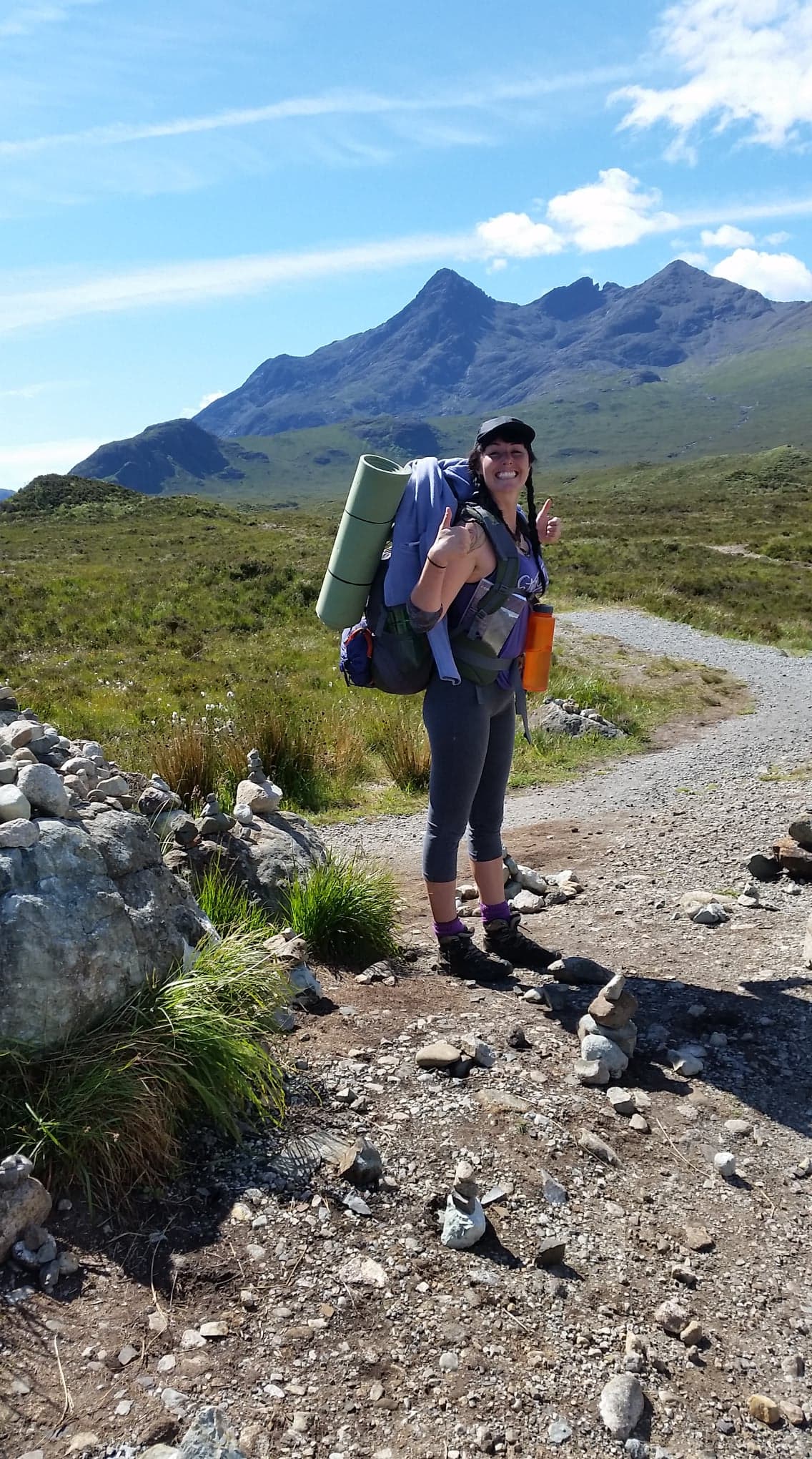 Amber on a hiking trail carrying her camping gear