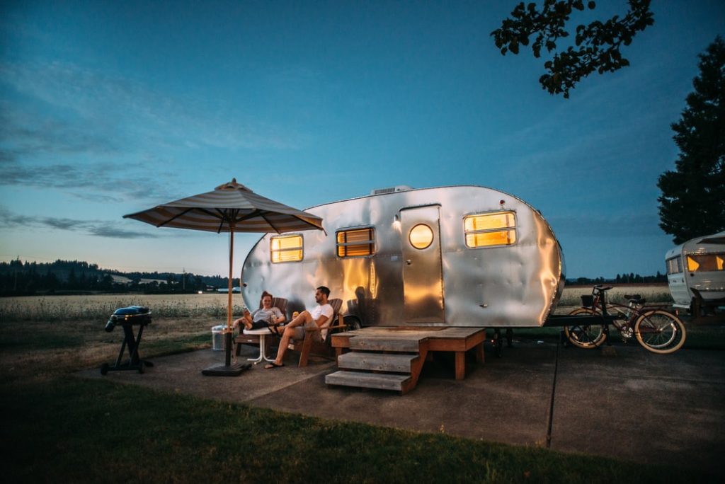 Young couple sitting outside their caravan