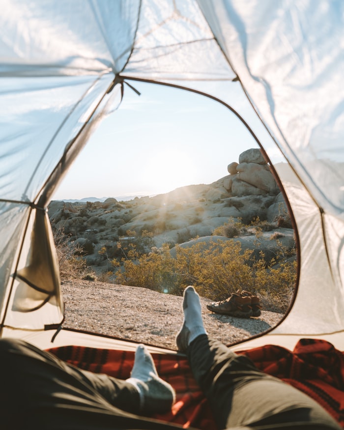 Person lying in tent with socks, blankets and warm clothing