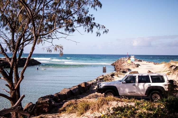 White 4wd parked at a beach